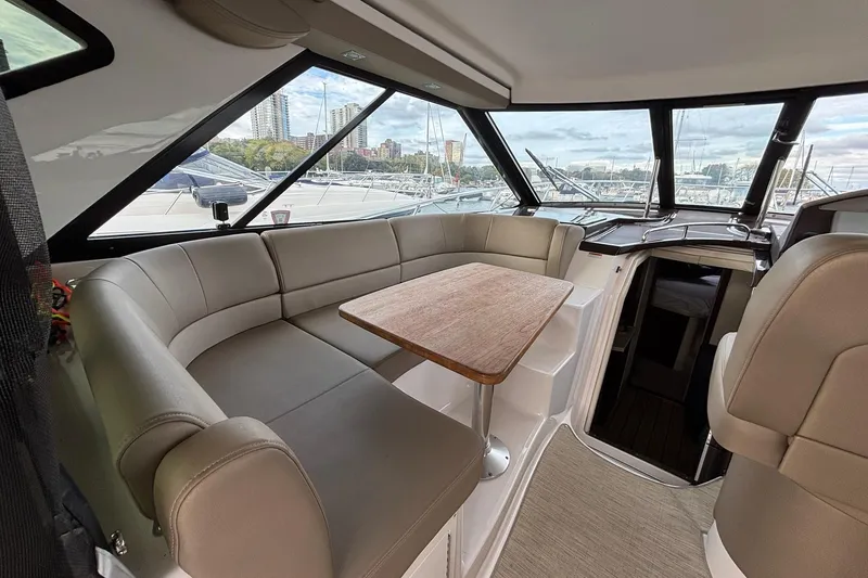Slide: The Image of Interior of 2015 Regal 42 Sport Coupe yacht with plush seating and wooden table. - 11