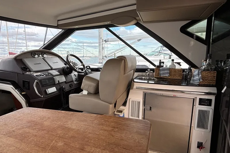Slide: The Image of Interior of a 2015 Regal 42 Sport Coupe yacht with helm and kitchenette. - 13
