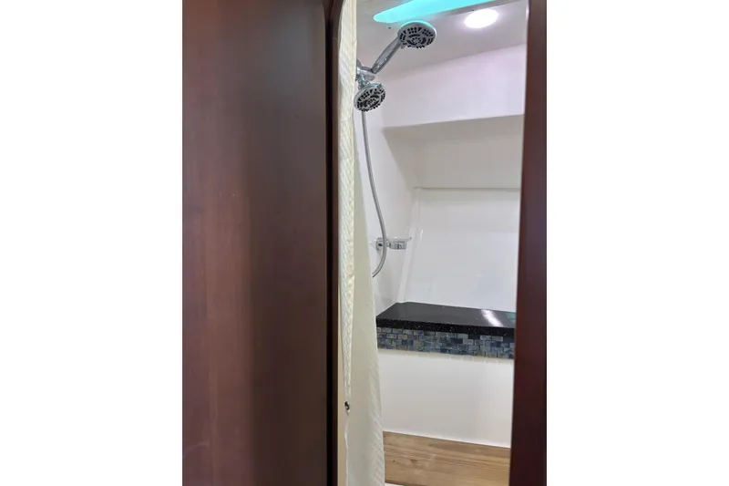 Slide: The Image of Shower area in 2015 Regal 42 Sport Coupe yacht with modern fixtures and wood accents. - 26