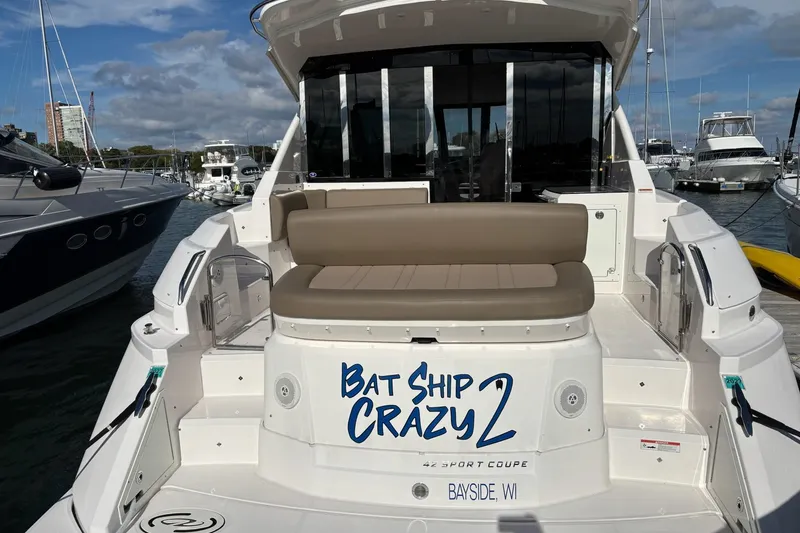 Slide: The Image of 2015 Regal 42 Sport Coupe yacht docked, featuring "Bat Ship Crazy 2" name on stern. - 7