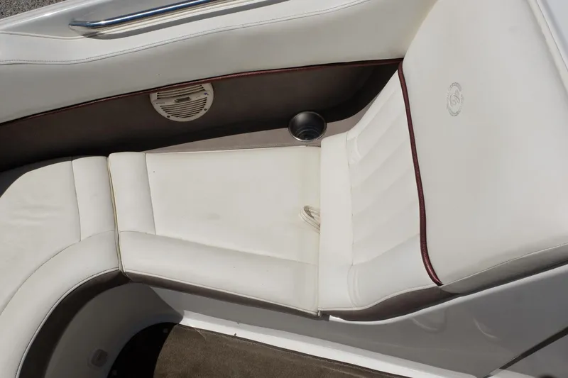 Slide: The Image of White leather seating in a 2004 Cobalt 200 boat, featuring cup holder and speaker. - 10