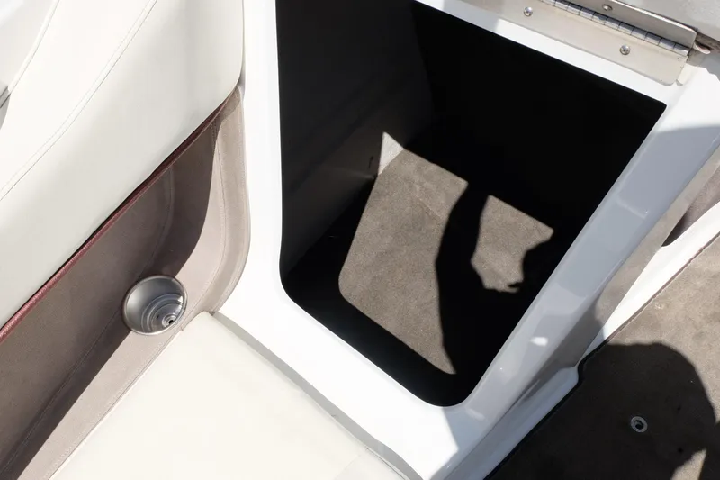 Slide: The Image of Interior storage compartment of a 2004 Cobalt 200 boat, featuring beige upholstery. - 11