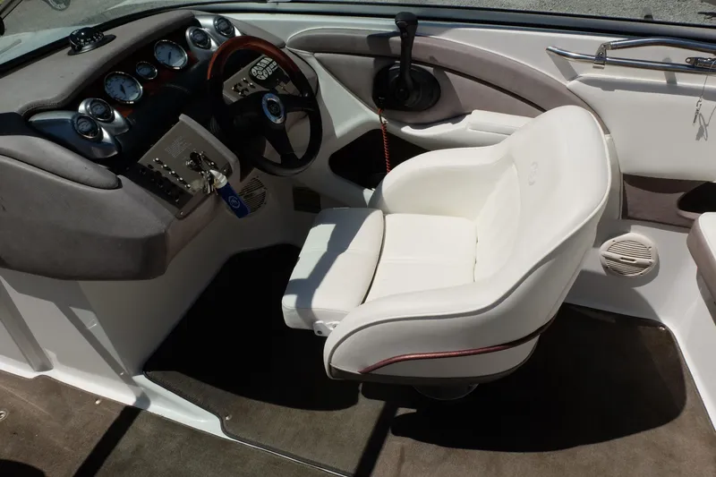Slide: The Image of Interior of a 2004 Cobalt 200 boat featuring a sleek dashboard and white captain's chair. - 16