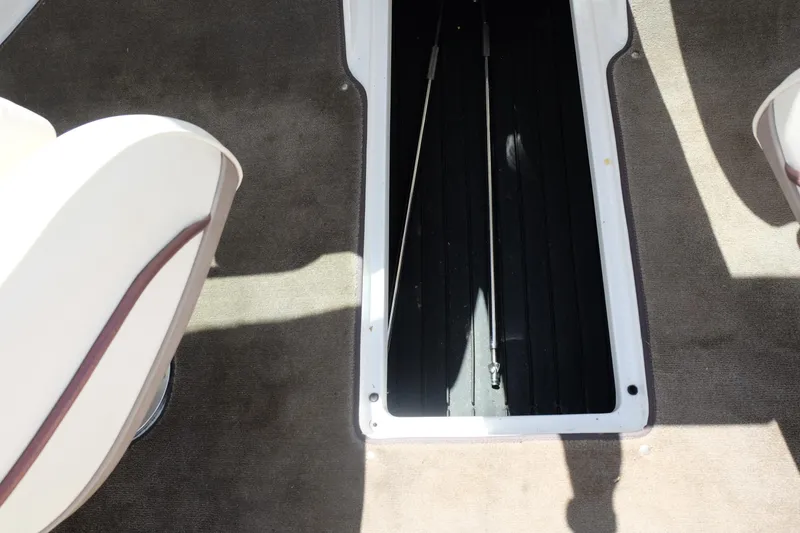 Slide: The Image of 2004 Cobalt 200 boat interior storage compartment with carpeted flooring. - 21