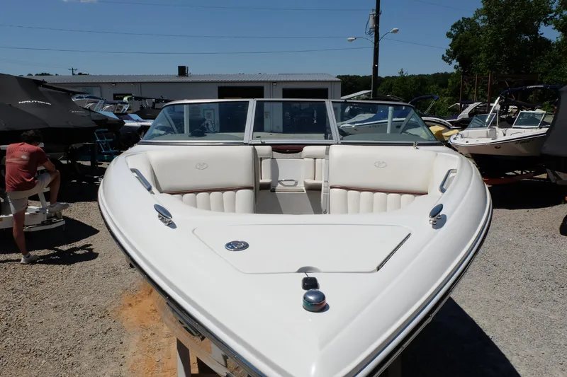 Slide: The Image of 2004 Cobalt 200 boat with white interior, parked outdoors under clear blue sky. - 3