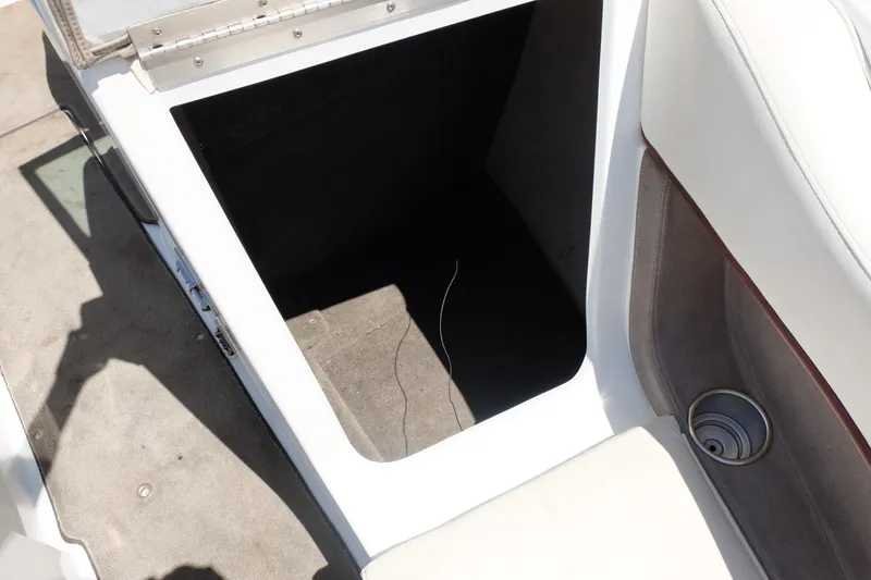 Slide: The Image of Open storage compartment in a 2004 Cobalt 200 boat, featuring white and beige interior. - 6