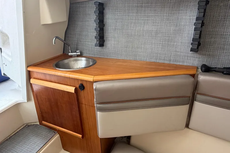 Slide: The Image of Compact kitchenette in 2020 Solara S-250 CW boat with sink and wooden cabinetry. - 27