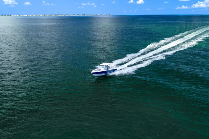 Slide: The Image of A 2026 Jupiter 32 boat cruising on open blue waters under a clear sky. - 10