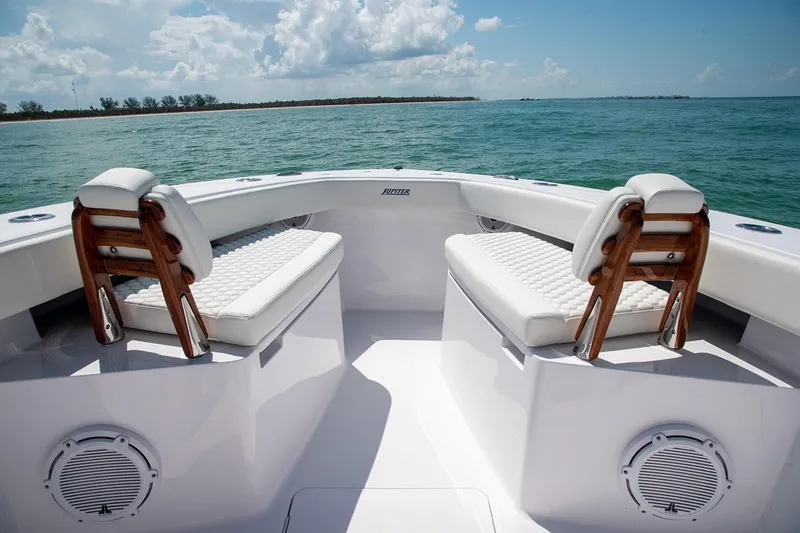 Slide: The Image of Manufacturer Provided Image: 2026 Jupiter 32 boat interior with cushioned seating, ocean view, and clear sky. - 3