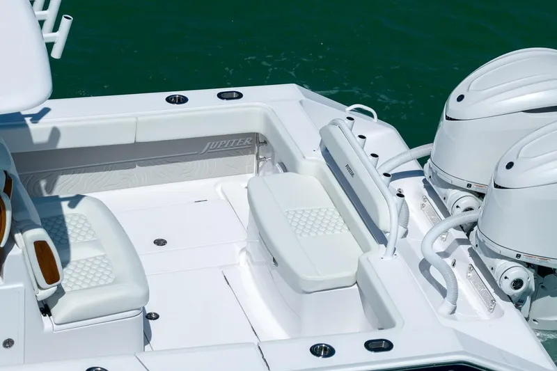 Slide: The Image of Manufacturer Provided Image: 2026 Jupiter 32 boat interior with white seating and dual engines on water. - 7