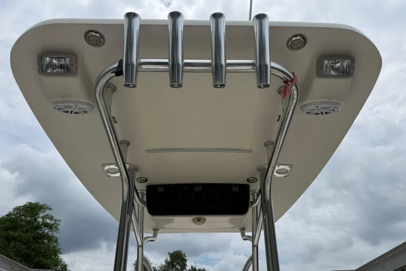 Slide: The Image of 2014 Key West 239 FS boat T-top with rod holders and speakers, under cloudy sky. - 21