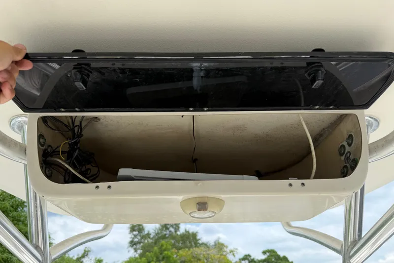 Slide: The Image of Open storage compartment on a 2014 Key West 239 FS boat, showing wiring and controls. - 24