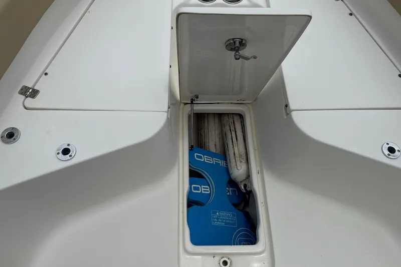 Slide: The Image of Open storage compartment on 2014 Key West 239 FS boat, containing blue life jackets. - 37