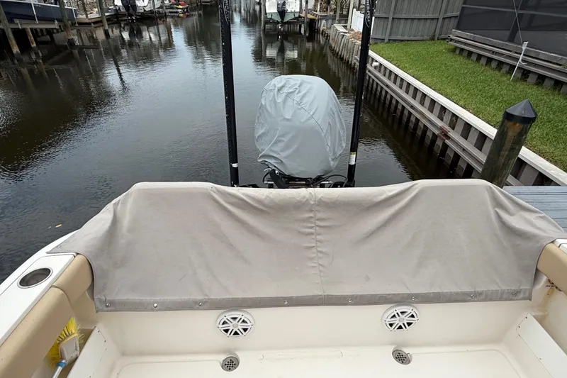 Slide: The Image of 2014 Key West 239 FS boat stern view with covered motor in a canal setting. - 5