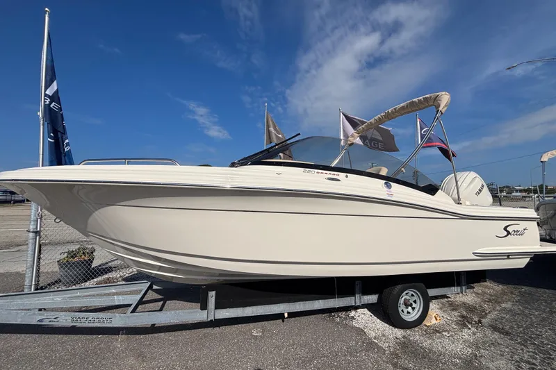 The Image of 2026 Scout 220 Dorado boat on trailer under clear blue sky. - 1