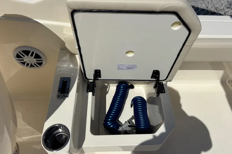 Slide: The Image of Open storage compartment on 2026 Scout 220 Dorado boat with coiled blue hose. - 18