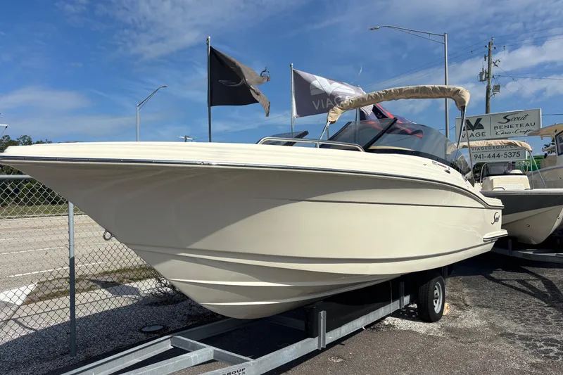 Slide: The Image of 2026 Scout 220 Dorado boat on trailer under clear blue sky. - 3