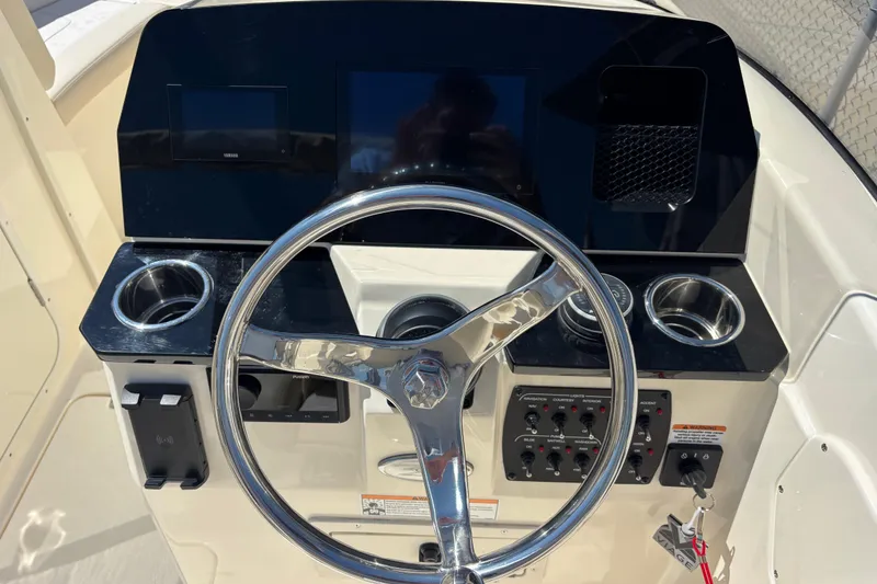 Slide: The Image of 2026 Scout 220 Dorado boat dashboard with steering wheel and control panel. - 8