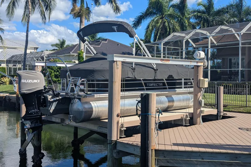 Slide: The Image of 2021 Trifecta 22RF LE pontoon boat docked with Suzuki outboard motor. - 11