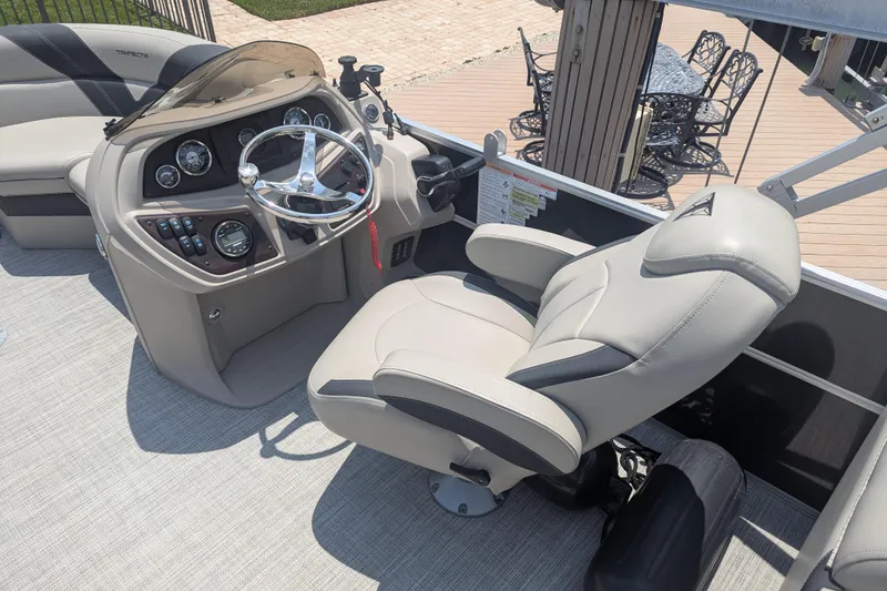 Slide: The Image of Captain's chair and helm of 2021 Trifecta 22RF LE pontoon boat, featuring modern controls. - 5