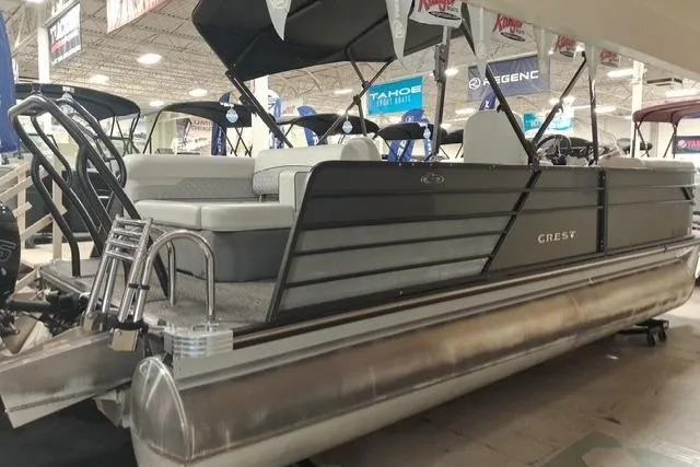 Slide: The Image of 2022 Crest Classic Platinum 220 pontoon boat displayed indoors at a showroom. - 2
