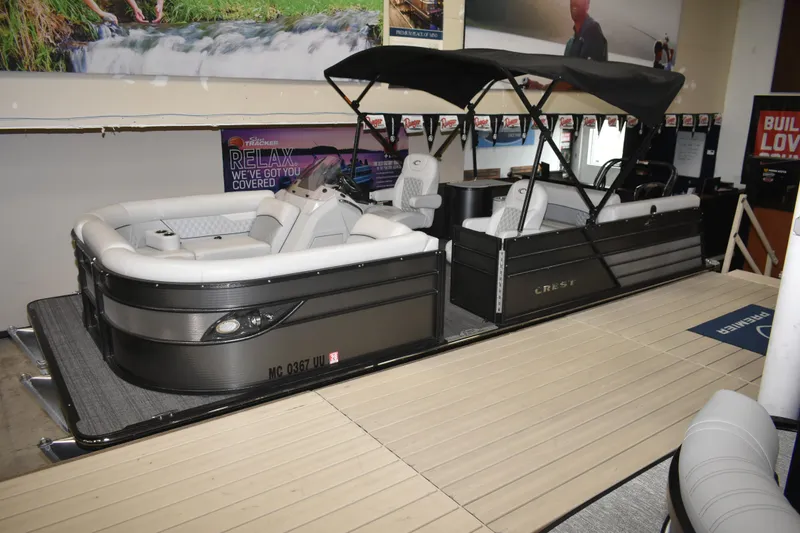 Slide: The Image of 2012 Crest 230 Prestige SLR pontoon boat displayed indoors with canopy and seating. - 4