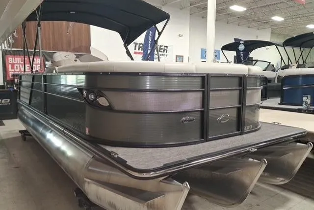 Slide: The Image of 2022 Crest Classic Platinum 220 pontoon boat displayed indoors at a showroom. - 5