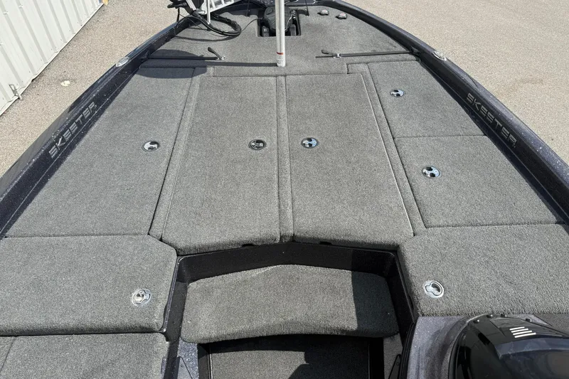 Slide: The Image of 2019 Skeeter ZX225 boat deck with gray carpet and storage compartments. - 14
