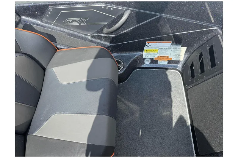 Slide: The Image of 2019 Skeeter ZX225 boat interior with seat and safety labels visible. - 16
