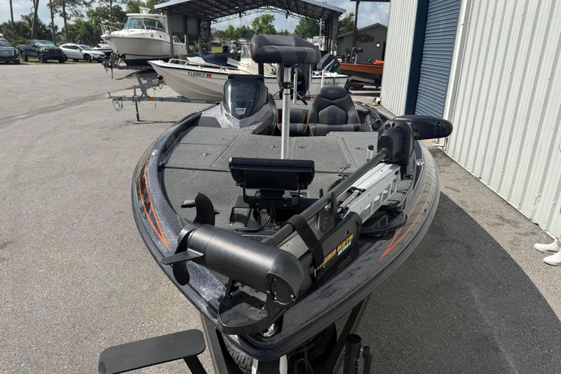 Slide: The Image of 2019 Skeeter ZX225 bass boat with trolling motor in a marina setting. - 9