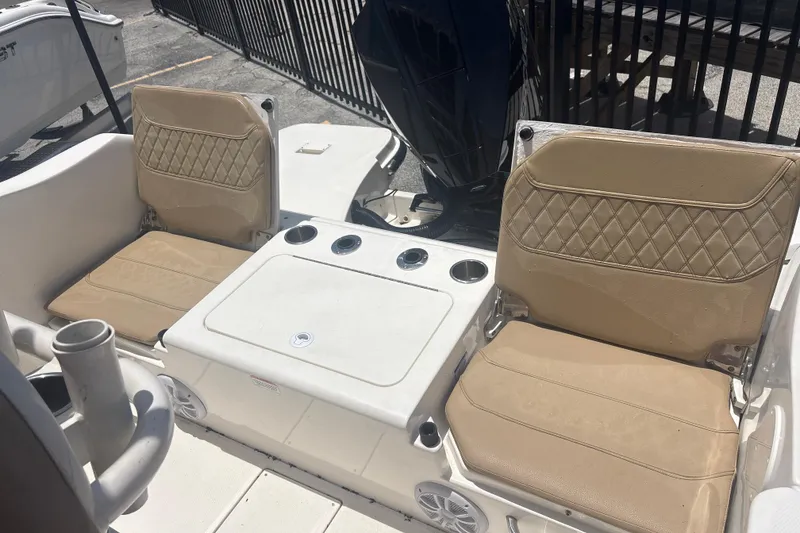 Slide: The Image of 2023 Bayliner Trophy T22CC boat interior with beige seating and cup holders. - 10