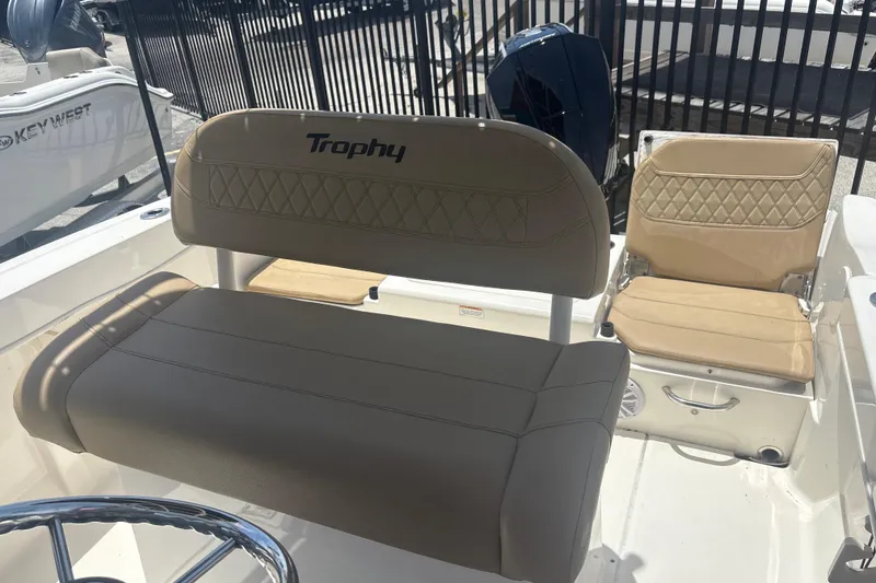 Slide: The Image of 2023 Bayliner Trophy T22CC boat interior with beige seating and steering wheel. - 5