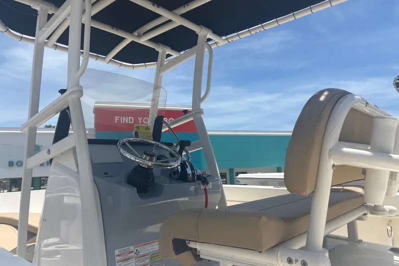 Slide: The Image of 2023 Bayliner Trophy T22CC boat interior with steering wheel and seating. - 7