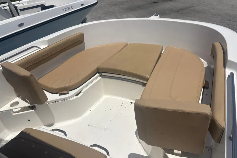 Slide: The Image of 2023 Bayliner Trophy T22CC boat with tan cushioned seating in the bow area. - 8