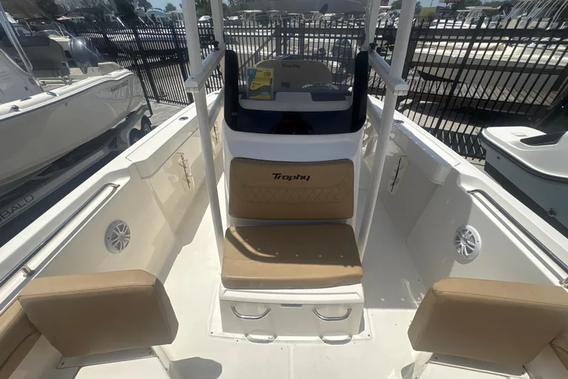 Slide: The Image of 2023 Bayliner Trophy T22CC boat interior with tan seating and center console. - 9