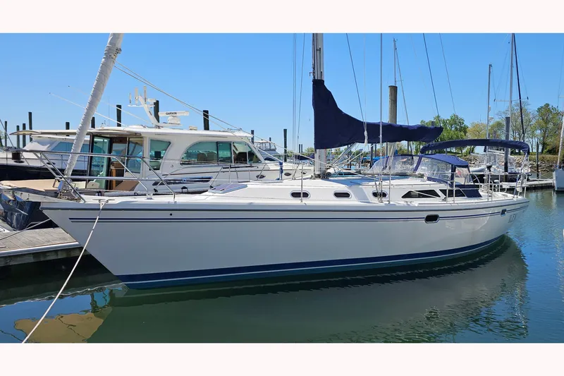 The Image of 2006 Catalina 42 MkII sailboat docked in a marina under clear blue skies. - 0