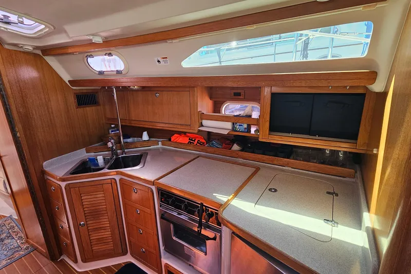 Slide: The Image of Interior of 2006 Catalina 42 MkII sailboat galley with wood cabinetry and modern appliances. - 21