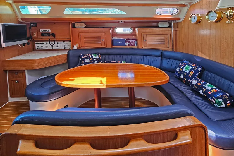 Slide: The Image of Interior of 2006 Catalina 42 MkII yacht with blue seating and wooden table. - 24