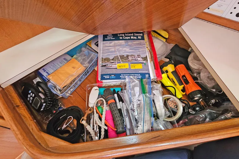 Slide: The Image of Drawer on Catalina 42 MkII yacht filled with navigational tools, maps, and equipment. - 37