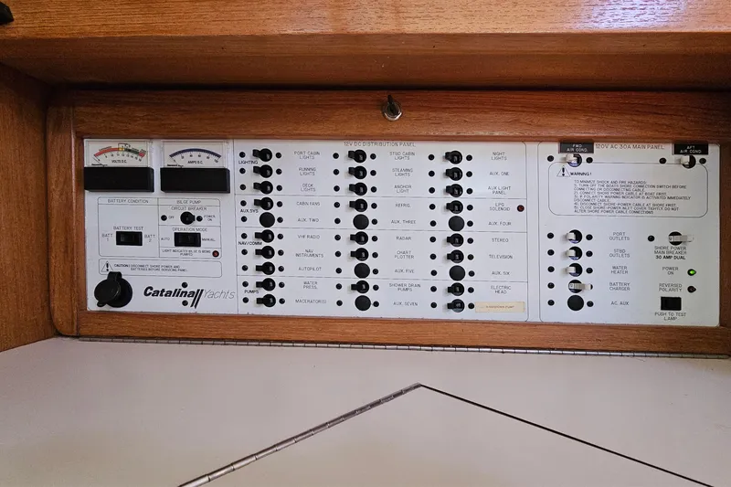 Slide: The Image of Electrical control panel of a 2006 Catalina 42 MkII yacht, featuring various switches and gauges. - 38