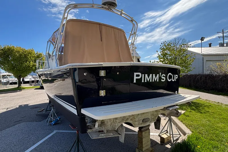Slide: The Image of 2006 Mainship Pilot 34 Sedan boat named "Pimm's Cup" on dry dock under clear sky. - 3