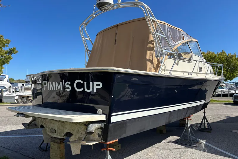 Slide: The Image of 2006 Mainship Pilot 34 Sedan boat named "Pimm's Cup" on dry dock under clear blue sky. - 4