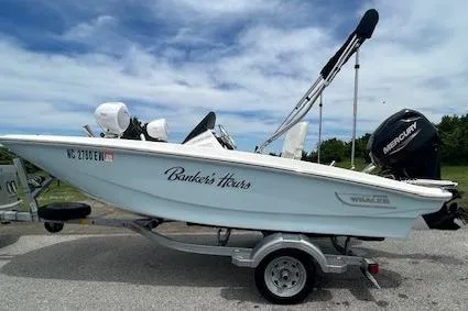Slide: The Image of 2020 Boston Whaler 130 Super Sport boat on trailer, side view, outdoors. - 1