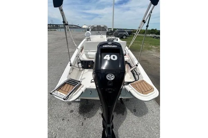 Slide: The Image of 2020 Boston Whaler 130 Super Sport boat with Mercury 40 engine, docked on a sunny day. - 2