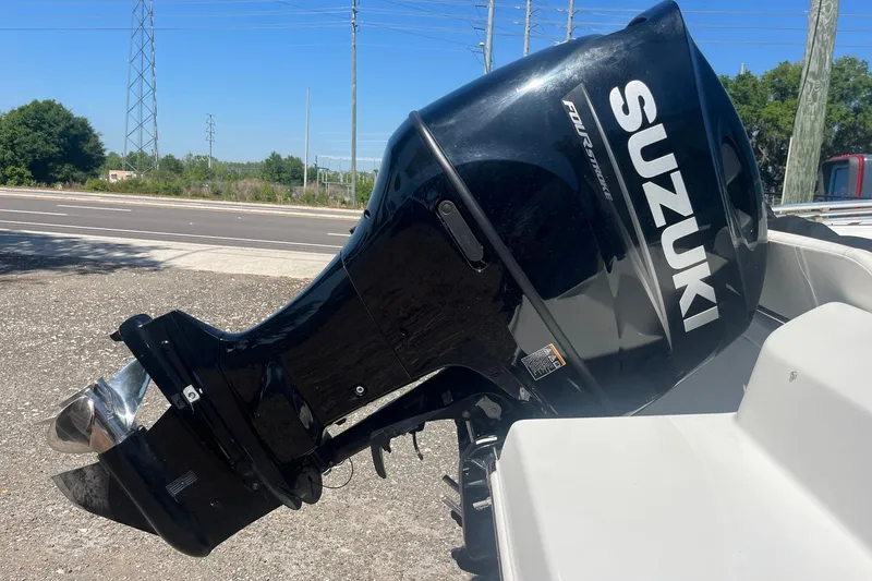 Slide: The Image of Suzuki outboard motor on 2007 NauticStar 2000XSDC Offshore boat, parked roadside. - 10