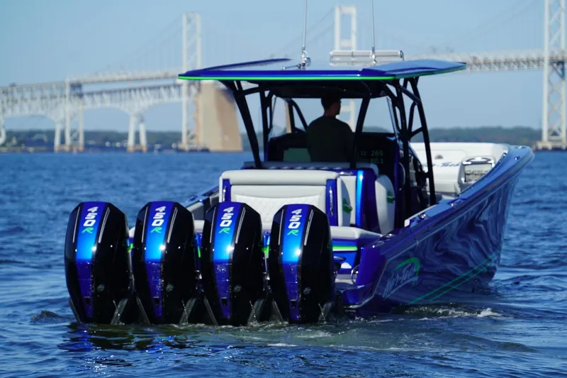 Slide: The Image of 2023 Nor-Tech 390 Sport Center Console boat with four powerful outboard engines on the water. - 11