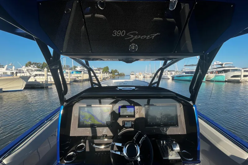 Slide: The Image of Cockpit view of 2023 Nor-Tech 390 Sport Center Console at marina, showcasing advanced navigation systems. - 12