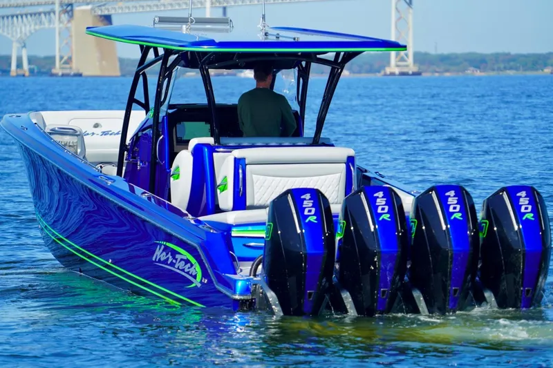 Slide: The Image of 2023 Nor-Tech 390 Sport Center Console boat with multiple powerful engines on open water. - 5