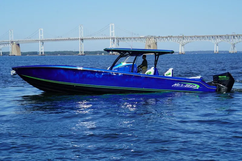 Slide: The Image of 2023 Nor-Tech 390 Sport Center Console boat cruising near a large bridge. - 6