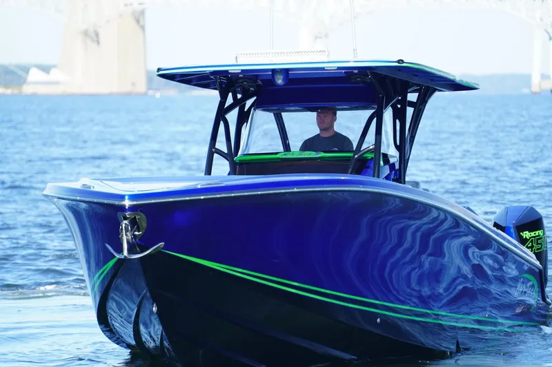 Slide: The Image of 2023 Nor-Tech 390 Sport Center Console boat on water, featuring sleek blue design. - 7